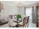 Beautiful dining room features a glass-top table and elegant decor with modern chandelier at 5457 Leslie Canyon Dr, Wimauma, FL 33598