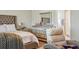 Luxurious main bedroom with tufted headboard, dresser, reclining chair and access to ensuite bathroom at 5457 Leslie Canyon Dr, Wimauma, FL 33598