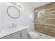 Modern bathroom featuring stylish vanity, decorative wood-look tile accent, and a glass-enclosed shower at 6010 Blossom Ave, Tampa, FL 33614