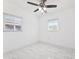 Bright bedroom featuring new tile floors, ceiling fan, and two windows at 6010 Blossom Ave, Tampa, FL 33614