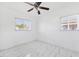 Bright bedroom features new tile floors, ceiling fan, and two windows at 6010 Blossom Ave, Tampa, FL 33614