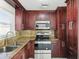 Kitchen featuring wood cabinets, granite countertops, and stainless steel appliances at 6010 Blossom Ave, Tampa, FL 33614