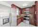 Well-lit kitchen with stainless steel appliances and dark wood cabinetry for ample storage at 6010 Blossom Ave, Tampa, FL 33614
