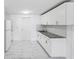 Bright kitchen featuring white cabinets, granite countertops, and modern flooring at 6010 Blossom Ave, Tampa, FL 33614