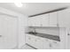 Kitchenette featuring all-white cabinetry, granite countertops and stainless steel sink at 6010 Blossom Ave, Tampa, FL 33614