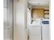Laundry room featuring white washer and dryer with overhead cabinet and open shelving at 623 Park Cir # 623, Bradenton, FL 34207