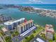 Breathtaking aerial view of waterfront condo building with boat docks, pool, and covered parking at 690 Island Way # 1011, Clearwater Beach, FL 33767