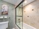 This bathroom offers a tub/shower combo with glass door and tiled walls, plus stylish heron artwork and decor at 690 Island Way # 1011, Clearwater Beach, FL 33767