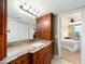 Bathroom vanity with wood cabinets, granite countertop, white sink and a view to the bedroom through the doorway at 690 Island Way # 1011, Clearwater Beach, FL 33767