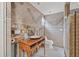 A bathroom featuring neutral tile, a vanity with wooden base, and a partially exposed wall at 7247 Oelsner St, New Port Richey, FL 34652