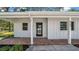 Inviting front entrance with brick-paved porch, stylish black door, and white siding, creating a modern and welcoming facade at 8262 26Th N Ave, St Petersburg, FL 33710