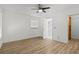 Bright bedroom with ceiling fan, wood floors, and an ensuite bathroom with a stand-up shower at 9155 125Th St, Seminole, FL 33772