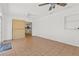 Open bonus room featuring tile floors, neutral walls, multiple fans, and a sliding barn door at 9155 125Th St, Seminole, FL 33772