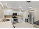 Well-lit kitchen features stainless steel appliances, white cabinets, and tile flooring at 9155 125Th St, Seminole, FL 33772