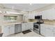 Kitchen features white cabinets, stainless steel appliances, and an open view to the next room at 9155 125Th St, Seminole, FL 33772