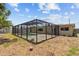A charming home featuring a screened-in pool and outdoor area, with a ball in the yard at 9155 125Th St, Seminole, FL 33772