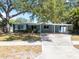 Charming single-story home featuring a covered carport and mature shade trees on a well-manicured lawn at 920 16Th Sw Ave, Largo, FL 33770
