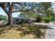 Single-story home with a covered carport, mature trees, and a partially shaded lawn, perfect for outdoor living at 920 16Th Sw Ave, Largo, FL 33770