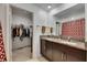 Bathroom showcasing double vanity with granite countertop and walk-in closet at 9907 Spanish Lime Ct, Riverview, FL 33578
