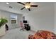 Modern bedroom with window, ceiling fan and a pink gaming chair at 9907 Spanish Lime Ct, Riverview, FL 33578
