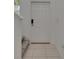 Clean entryway with neutral tile, a white door with a digital lock, and the carpeted stairs leading to the next level at 9907 Spanish Lime Ct, Riverview, FL 33578