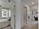 Hallway leading to bedrooms, each with a ceiling fan and neutral colored walls at 9907 Spanish Lime Ct, Riverview, FL 33578