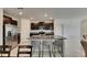 Open kitchen with an island featuring barstool seating, granite countertops, stainless appliances, and dark cabinetry at 9907 Spanish Lime Ct, Riverview, FL 33578