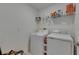 Clean laundry room with white appliances, shelving, and ample space for organization at 9907 Spanish Lime Ct, Riverview, FL 33578