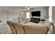 Bright living room featuring comfortable reclining sofas, modern entertainment center, and a ceiling fan at 9907 Spanish Lime Ct, Riverview, FL 33578