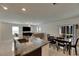 Open-concept living space with granite island, dining area, and sliding glass doors for seamless indoor/outdoor living at 9907 Spanish Lime Ct, Riverview, FL 33578