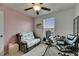 This is a home office featuring a ceiling fan, a window with blinds, a small sofa, and a desk at 9907 Spanish Lime Ct, Riverview, FL 33578