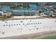 Beautiful aerial view of condo on the beach with clear blue water and plenty of beach umbrellas at 9980 Gulf Blvd # 603, Treasure Island, FL 33706