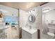 A modern bathroom featuring updated vanity with sink, decorative mirror, and a view into the Primary bedroom at 9980 Gulf Blvd # 603, Treasure Island, FL 33706