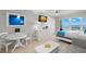 Cozy living area with a dining set, white furniture, TV, and ocean views from the sliding glass doors at 9980 Gulf Blvd # 603, Treasure Island, FL 33706