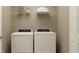 Functional laundry room featuring a washer, dryer, and storage shelves at 10282 Purple Leaf Ct, Riverview, FL 33578