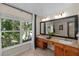 Bathroom featuring granite countertops, double sinks, large window with natural light, and a dark framed mirror at 1133 Split Silk St, Valrico, FL 33594