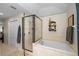 Bright bathroom features a soaking tub, walk-in shower with glass surround, and neutral tile at 1133 Split Silk St, Valrico, FL 33594