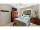 Bedroom with ceiling fan, window, and wooden furniture including armoire, bench, and nightstand at 1133 Split Silk St, Valrico, FL 33594