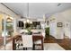 Inviting dining area with a wooden table, decorative lighting, and seamless flow to the kitchen and outdoor pool area at 1133 Split Silk St, Valrico, FL 33594