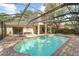 Backyard screened-in pool with brick patio and surrounding greenery with attached home at 1133 Split Silk St, Valrico, FL 33594