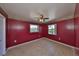 Cozy bedroom with vibrant red walls, tiled floors, and two windows for plenty of light at 1207 Norwich Cir, Sun City Center, FL 33573