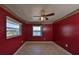 Cozy bedroom with vibrant red walls, tiled floors, and a picturesque water view at 1207 Norwich Cir, Sun City Center, FL 33573