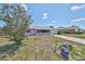 Charming pink single-story home with a screened-in porch and lovely stone driveway at 1207 Norwich Cir, Sun City Center, FL 33573