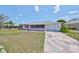Inviting pink home featuring a cozy screened-in porch and patterned stone driveway at 1207 Norwich Cir, Sun City Center, FL 33573