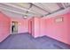 Spacious two-car garage painted in a bold pink color with carpeted floors at 1207 Norwich Cir, Sun City Center, FL 33573
