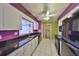 Colorful kitchen with black appliances, a double sink, white cabinetry, and a view to the laundry room at 1207 Norwich Cir, Sun City Center, FL 33573