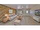 Inviting living room featuring a unique wood accent wall, neutral furniture, and a ceiling fan at 1207 Norwich Cir, Sun City Center, FL 33573