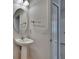 Bathroom featuring pedestal sink, oval mirror, towel rack, and white door, with neutral wall color at 12150 Ledbury Commons Dr, Gibsonton, FL 33534