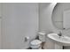 Half bathroom with pedestal sink, mirror, toilet, and light beige walls at 12150 Ledbury Commons Dr, Gibsonton, FL 33534