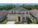 Two-story home with a well-manicured lawn and complemented by landscaping, a driveway and an attached two-car garage at 12150 Ledbury Commons Dr, Gibsonton, FL 33534